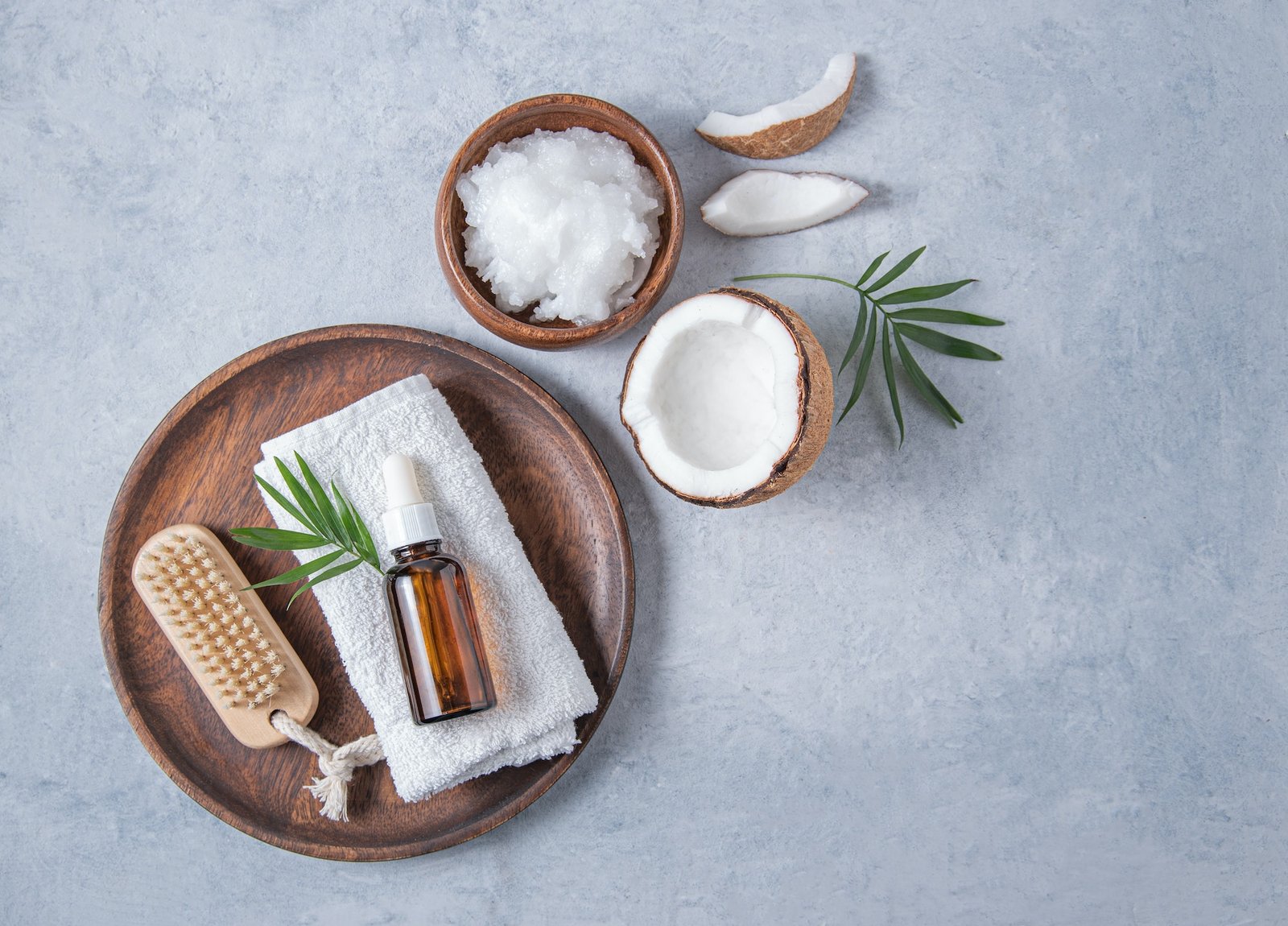 concept of organic spa flat lay. Healthy coconut oil with a wooden brush and half a coconut